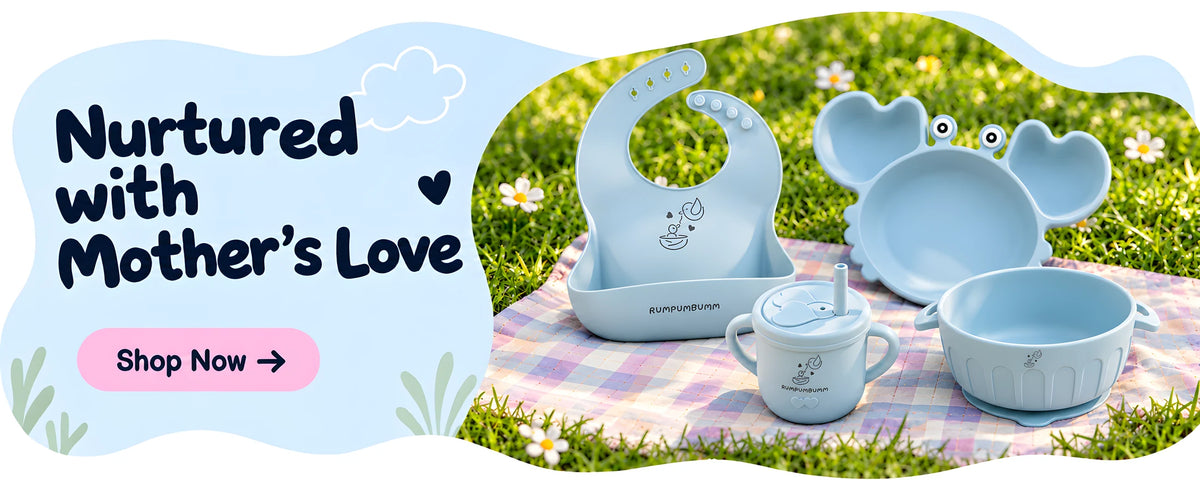 Nurtured with Mother’s Love. Shop now: an Ice Blue bib, crab plate, Straw Sippy Cup With Open Lid and bowl on a picnic blanket.